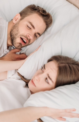 Frustrated woman in bed with snoring man