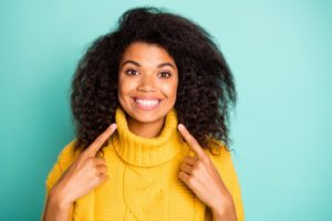 woman pointing at her smile with tooth-colored fillings